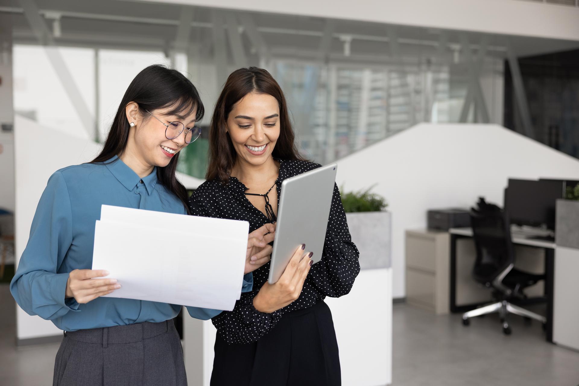 Two professionals reviewing and sharing documents in Philips SpeechLive on a tablet.