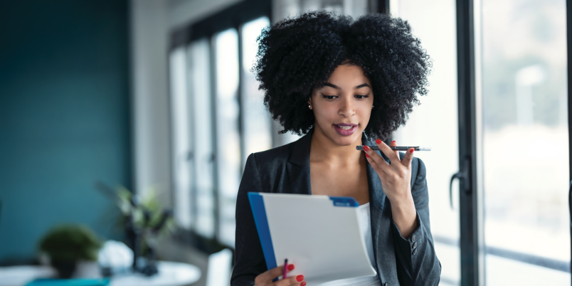 Businesswoman speaking on the phone holding files in her hand