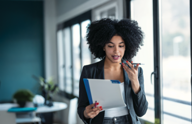 Businesswoman speaking on the phone holding files in her hand