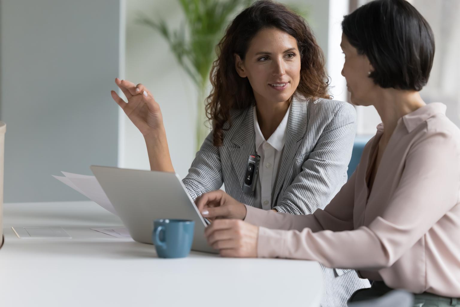 Business colleagues talking at workplace and recording with Philips SpeechMike Ambient
