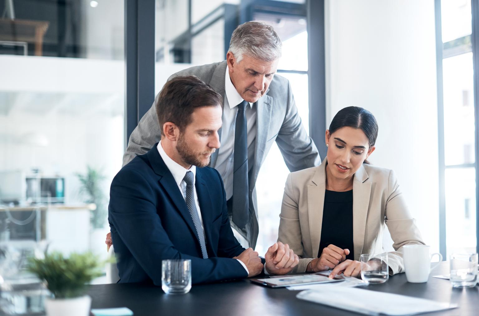 Three professionals reviewing business documents created with Philips SpeechLive.