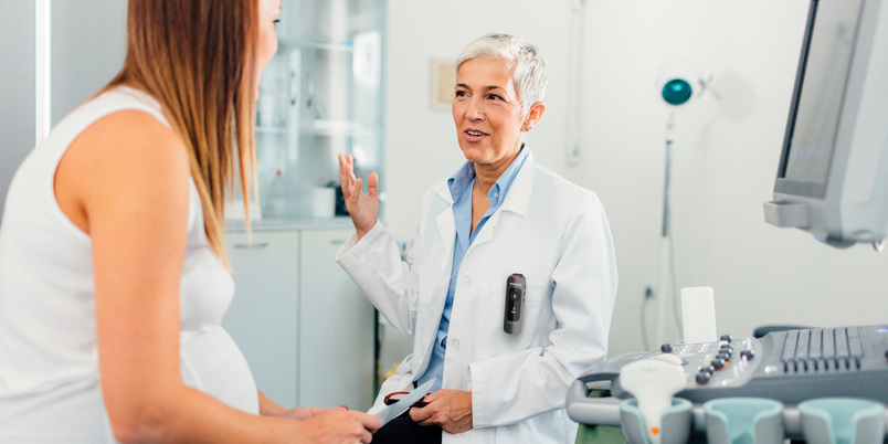 Physician wearing a Philips SpeechMike Ambient performing prenatal ultrasound imaging