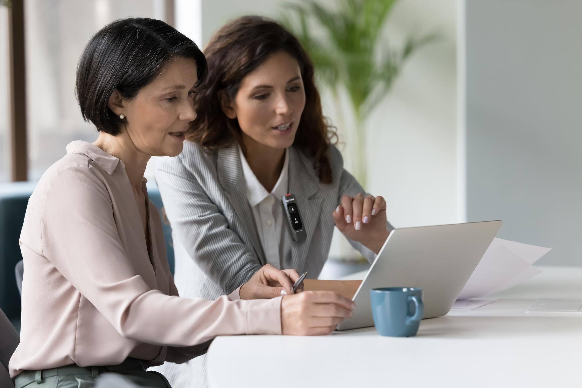 Business colleagues talking at workplace and recording with Philips SpeechMike Ambient