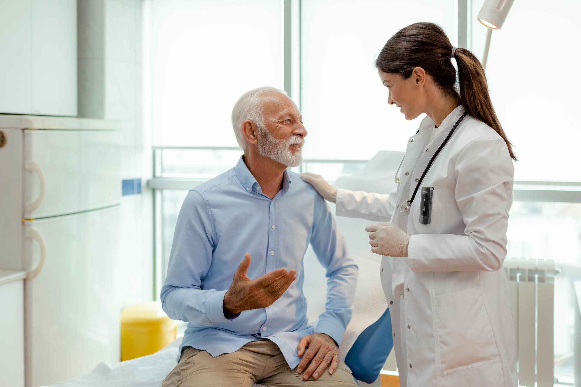 Female doctor talking with senior patient while recording with Philips SpeechMike Ambient