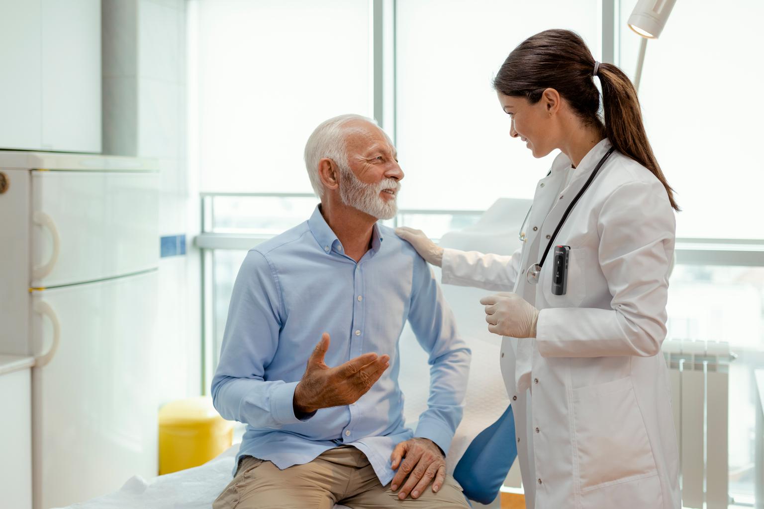 Female doctor talking with senior patient while recording with Philips SpeechMike Ambient