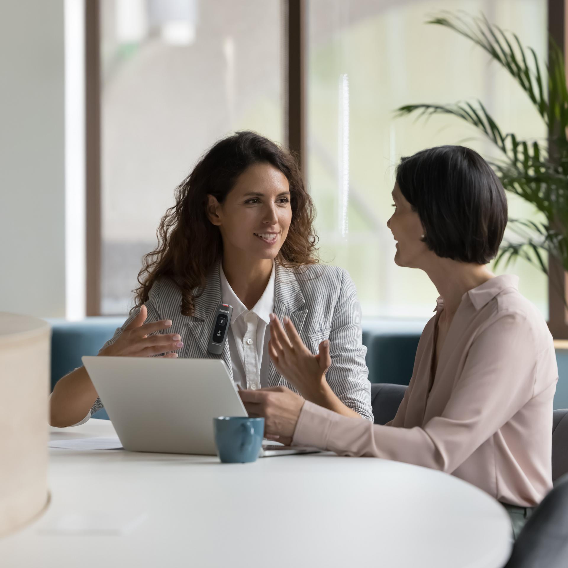 Business colleagues talking at workplace and recording with Philips SpeechMike Ambient